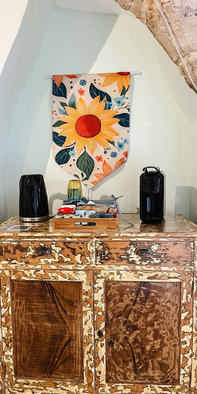 Angolo caffè del Girasole sulla credenza d'epoca, con bollitore, macchina da caffè e arazzo con girasole