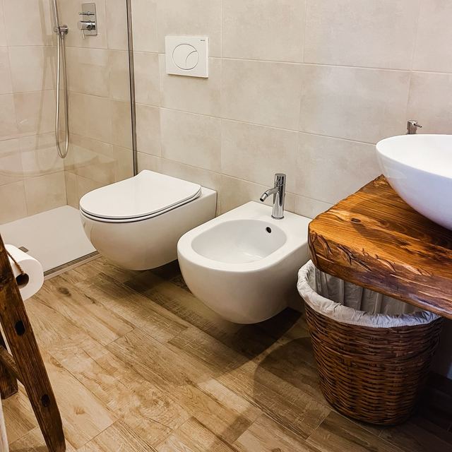 Bagno privato del Girasole con doccia walk-in, sanitari sospesi, bidet e mobile in legno massello