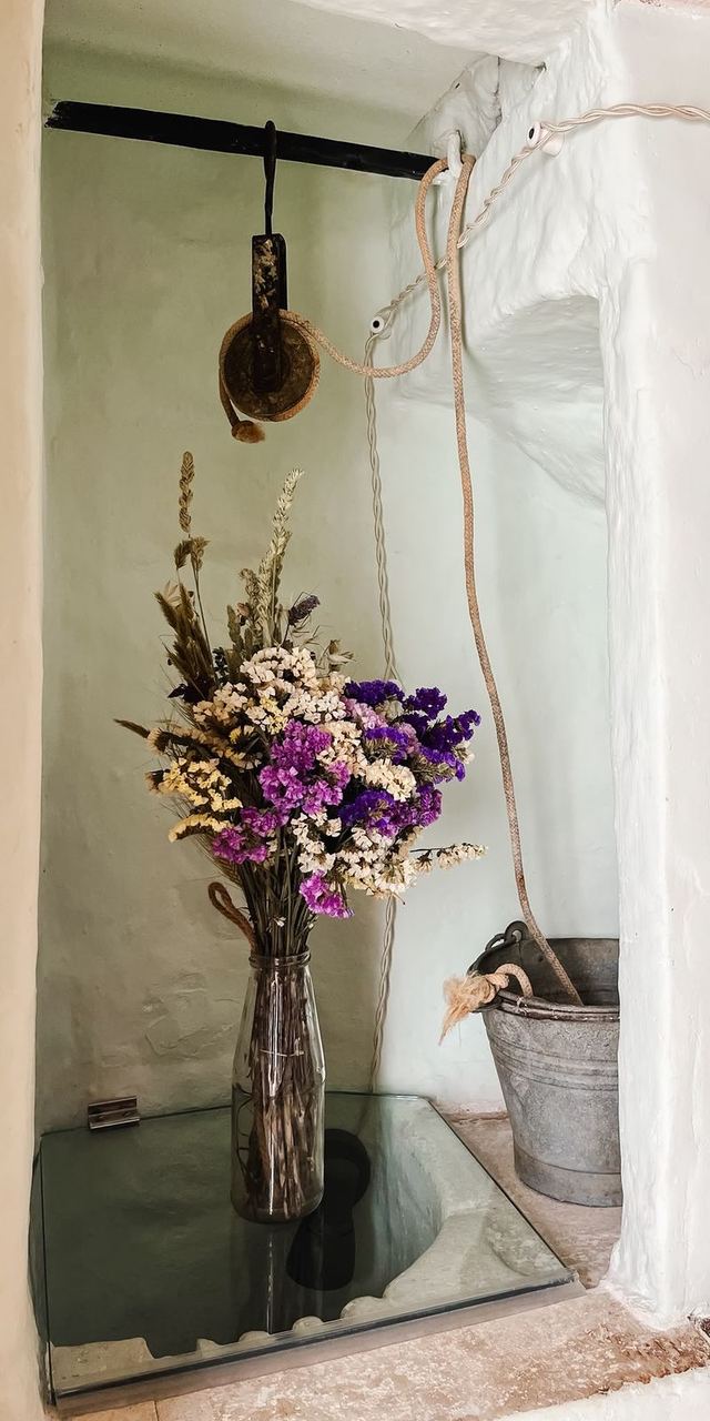 Nicchia storica del Girasole con carrucola, secchio d'epoca e bouquet di fiori secchi