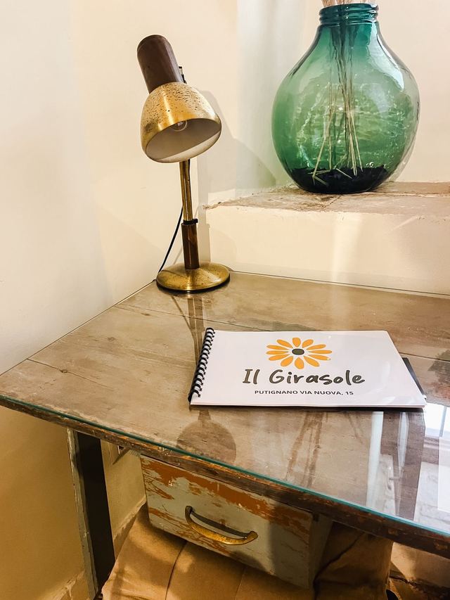Scrittoio del Girasole con lampada d'epoca, damigiana verde e la guida per gli ospiti